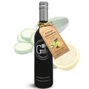 A dark glass bottle of Georgetown Olive Oil Co Lemon Cucumber White Balsamic, featuring the Georgetown Olive Oil Co. logo on its label and a brown tag, is placed in front of cucumber slices and a lemon half. This refreshing balsamic is crafted with aged white balsamic vinegar from Modena, Italy.