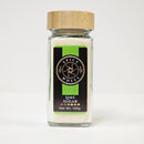 A glass jar with a bamboo lid holds Spice Wheel Lime Sugar, featuring a vibrant green and black label that displays the Spice Wheel brand logo and product details. The 105g jar highlights its refreshing citrus flavor and fine granulated sugar texture.
