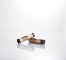 Two tubes from The Immaculate Beard Grooming Gift Set are displayed on a glossy white surface—one upright, the other resting horizontally—each with a brown label, black text, and mustache logo, making them an ideal match for your favorite beard oil or an essential addition to your beard care routine from The Immaculate Beard.