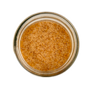A top-down view of SALTOPIA Infused Sea Salts' Saltopia Pumpkin Spice Sugar: LOVIN' MY PUMPKIN in a glass jar, showcasing coarse, light brown gourmet infused sugar granules against a white background.