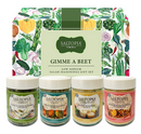 Four jars of Saltopia Low Sodium Salad Seasonings—Garlic & Chives, Dill & Lemon, Ranch, and Maple Mustard—from SALTOPIA Infused Sea Salts are displayed before a veggie-themed box. The Gimme A Beet set makes salads flavorful and fun.