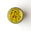 An open jar of Taycte Famiglia Crispino Sliced Eggplant Antipasto — marinated Italian melanzane in olive oil, viewed from above on a white background, showcases authentic Calabria flavor.