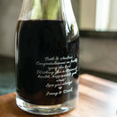 The Diamond wine decanter filled with dark wine, engraved with a wedding congratulation message for Beth and Andrew from Jenny and Derek.