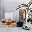 A Swanky Badger Whiskey Essentials Bundle featuring four personalized whiskey glasses engraved with Smith, a stainless steel cocktail shaker, a jigger, a Hawthorne strainer, and a stack of black leather coasters.