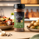 A bottle of Texan Heartland Master Blend All-Purpose Seasoning by Texan Heartland sits on a kitchen counter, surrounded by roasted vegetables, potatoes, and juicy grilled meat, adding bold Texas-style flavor to every dish against a softly blurred kitchen backdrop.
