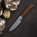 A Messermeister Adventure Chef Maple Basecamp Set - 3 Piece folding knife with a wooden handle lies open on a dark surface beside clusters of assorted oyster mushrooms.