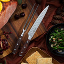 The Messermeister Avanta Pakkawood Knife Block Set - 10 Piece rests on a wooden board beside slices of ham, cherries, pomegranate, green beans with almonds, pine cones, and crackers atop a brown tablecloth.