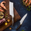 A Messermeister Kawashima 6" Utility Knife with a dark wood handle rests on a wooden surface beside chopped vegetables, corn, cherry tomatoes, herbs, and uncooked shrimp—illustrating kitchen prep in action.