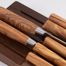 Close-up of several kitchen knives in the Messermeister In-Drawer Knife Holder - 11 Slot, neatly arranged for stylish and organized storage by Messermeister. Smooth walnut handles and metal collars visible against a white background.