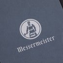 A gray surface displays the white Messermeister logo—a person in an apron with a knife—above “Messermeister,” highlighting the Restoration Stone’s dual 400 & 1000 grits for effective knife sharpening.