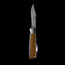 The Messermeister Adventure Chef Maple Folding Camp Utensil, by Messermeister, features a partially serrated blade and a wooden handle, shown open against a solid black background.