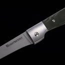 Close-up of a Messermeister Adventure Chef Linen Folding Flexible Fillet Knife - 6" with a partially open stainless steel blade and dark textured handle, set against a black background.