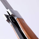 Close-up of the Messermeister Adventure Chef Maple Folding Peeler & Parer, featuring a wooden handle and partially open stainless steel blade, resembling a compact folding peeler, shown against a plain white background.