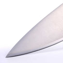 Close-up of the pointed tip and sharp edge of the Messermeister Blacksmith Chef's Knife - 8" stainless steel blade against a white background.