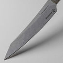 Close-up of the Messermeister Carbon Utility - 6" knife, featuring a sharp, pointed high-carbon steel blade labeled "CARBON" and "Messermeister," displayed against a clean white background.
