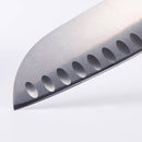 Close-up of the Messermeister Custom Blue Kullens Santoku Knife - 7", showing its hollow-ground blade with oval-shaped indentations, set against a plain white background.