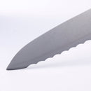 Close-up of the tip and serrated edge of a gray knife blade from the Messermeister Custom Next Level 5-Piece Magnetic Knife Block Set, displayed against a plain white background, highlighting the expert craftsmanship that makes Messermeister blades essential for any efficiently organized kitchen.