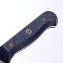 Close-up of a textured black handle featuring three visible screws, belonging to a Messermeister Custom Next Level knife, set against a white background. The partially visible blade hints at its inclusion in the Messermeister Custom Next Level 5-Piece Magnetic Knife Block Set—an organized kitchen storage solution for precision cutting tools.