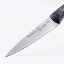 A close-up of the Messermeister Custom Paring Knife - 3.5" shows its sharp, pointed steel blade engraved with the brand name, and part of the black handle visible against a white background.