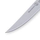 Close-up of the pointed tip and blade from a Messermeister Custom Red 4 Piece Steak Knife Set, showing the engraved brand logo on cold-rolled steel against a white background.