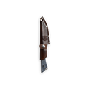 The Messermeister Iron & Resin Overland Chef 4.5″ Utility Knife, a fixed-blade utility knife with a short, wide blade, is partially tucked into a dark brown leather sheath featuring metal rivets and a circular embossed design. Displayed against a plain white background, this Messermeister knife is ideal for camp cooking or outdoor tasks.