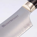 Close-up of the Messermeister Kawashima Nakiri Knife - 6.5" blade, with "Messermeister" and Japanese characters engraved, showcasing its SG2 powdered steel, polished finish, wood handle, and metallic bolster.