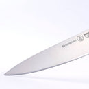 A close-up of the blade of a Messermeister Meridian Elite Chef's Knife - 8", showcasing its sharp edge and part of the Messermeister logo, set against a plain white background.