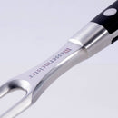 Close-up of the Messermeister Meridian Elite Kullens Carving Set's metal fork with a black handle, featuring two prongs, durable metal rivets, and the Messermeister brand name engraved on the metal—designed to pair with a carving knife.