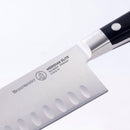 A close-up of the Messermeister Meridian Elite Kullens Santoku Knife - 5” showcases its high-carbon stainless steel blade with kullens (hollow edge), distinct logo, brand name, and handle—reflecting fine German craftsmanship.