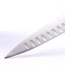 Close-up of the pointed tip and blade of the Messermeister Meridian Elite Kullens Slicer - 10", showing oval-shaped indentations along the side, set against a white background.