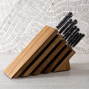 The Messermeister Meridian Elite Next Level Block Set - 11 Piece, featuring black handles, is displayed in a magnetic block on a light gray surface with a patterned white and gray background.