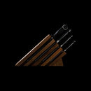 The Messermeister Meridian Elite Next Level Block Set - 5 Piece includes four German stainless steel knives with black handles (including a chef's knife) and a sharpening rod in a wooden block, all elegantly displayed against a black background.