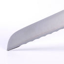 Close-up of the serrated edge and tip of the Messermeister Meridian Elite Scalloped Utility Knife - 5", a precision-forged high-carbon stainless steel blade, against a white background.