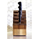 A Messermeister Next Level Magnetic Knife Block with black-handled knives sits on the countertop, set against a white hexagonal tile backsplash.