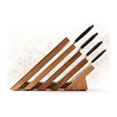 Four kitchen knives with black handles are stored in a Messermeister Next Level Magnetic Knife Block by Messermeister, set against a white hexagonal tile backsplash.