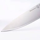 Close-up of the sharp, shiny blade of the Messermeister Oliva Elite Chef's Knife - 9" with a stunning olive wood handle, displayed against a plain white background.