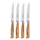 The Messermeister Oliva Elite Fine Edge 4-piece steak knife set features German stainless steel blades and light brown olive wood handles, shown lined up side by side on a white background.