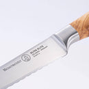 Close-up of the Messermeister Oliva Elite Reverse Scalloped Utility Knife - 6", featuring a German stainless steel blade engraved with Messermeister and a distinctive olive wood handle. Shown against a plain white background.