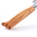 Close-up of the Messermeister Oliva Elite 9" Scalloped Bread Knife, featuring a smooth, light brown olive wood handle with natural grain patterns, set against a white background.