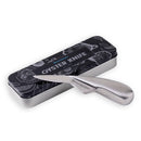 A Messermeister Oyster Knife - 6.5" with a stainless steel blade and ergonomic handle sits in front of a rectangular black and silver tin box labeled with the brand name and seafood-themed illustrations.