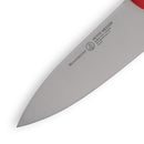 Close-up of the Messermeister Petite Messer Red Chef's Knife - 5" blade, made from high-carbon stainless steel with a sharp edge and a partially visible red handle.