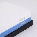 A close-up of the Messermeister Polishing Stone - 2000 & 5000 Grit, showing white (5000 G) and blue (2000 G) layers for knife sharpening, both labeled and resting on a black base. Brand: Messermeister.