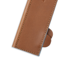 Close-up of the Messermeister Saddle Brown Leather Magnetic Edge-Guard (10.5") with visible stitching, partially covering two chef’s knives on a white background, designed for safe knife storage.
