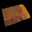 The Messermeister Vintage Leather Amber Knife Roll - 7 Pocket is open on a black background, showing several pockets and a flap for securing tools.