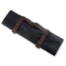 Store your chef knives in style with the Messermeister Vintage Leather Black Knife Roll - 7 Pocket, crafted from black vintage leather with two brown straps, brass buckles, and a handle for easy carrying.