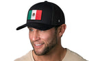 A man wearing a black Haka Hat Mexican Flag Trucker Hat (Mexico Snapback) smiles for the camera.