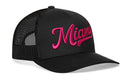 The Haka Hat Miami Hot Pink Script Trucker Hat is a black Florida snapback with "Miami" embroidered in hot pink script, featuring a curved brim and mesh back panels for classic style and breathability.