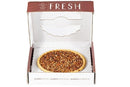 A classic 9-inch Millican Pecan Southern Bourbon Pecan Pie sits centered inside a white bakery box with a red lid that reads “FRESH.” This southern dessert from Millican Pecan is generously topped with chopped pecans, making it the perfect treat for any occasion.