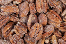 A close-up view of Millican Pecan Cinnamon Candied Pecans – 12 oz Bag shows pecans from Millican Pecan coated in a sweet layer of cinnamon, sugar, and spices for a crunchy, textured finish.