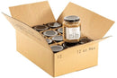Open box of Millican Pecan Creamy Pecan Butter - 8.5 oz Natural Texas Pecan Spread, 12 jars inside, one jar on top. Jar label visible. Made with rich Texas pecans by Millican Pecan.